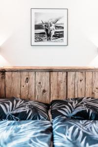 ein Bild einer Kuh an einer Wand über einem Bett in der Unterkunft Southern Stables Ranch in Bannberg