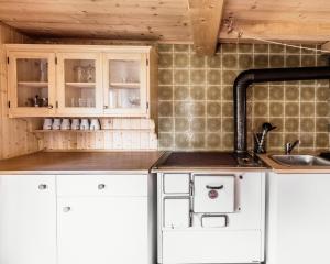 a kitchen with white cabinets and a sink at Fohlenwies - romantische Berghütte in Alleinlage Osttirol in Lienz