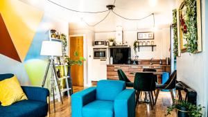 Una sala de estar con sillas azules y una mesa. en Beyond Blonk Apartments, en Sheffield 6 fotos más