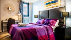 sypialnia z dużym łóżkiem i fioletowym kocem w obiekcie Beyond Blonk Apartments w Sheffield