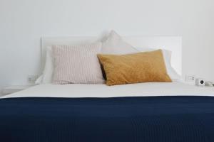 uma cama branca com duas almofadas em cima em Habitación con baño y entrada independiente em La Santa