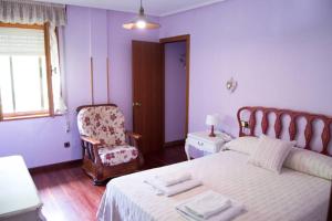 a bedroom with a bed and a chair and a window at Casa Fresneda in Fresneda