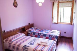two beds in a room with purple walls and a window at Casa Fresneda in Fresneda +18 photos