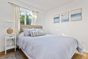 a white bedroom with a bed and a window at Vista House Unit B in Tillamook