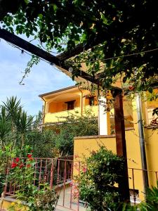 una casa gialla con una recinzione di fronte di Camere Sinis Isprocilis a Palmas Arborea