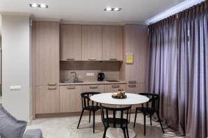a room with a table and chairs and a kitchen at Апартаменты Central Park в центре Тюмени in Tyumen