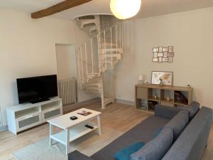 - un salon avec un canapé et un escalier en colimaçon dans l'établissement Elégant Appartement T3 hypercentre de Mazamet, à Mazamet