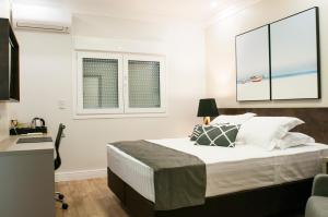 a bedroom with a bed and two windows at Hotel Kindermann in Caçador