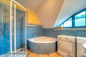 a blue tiled bathroom with a tub and a sink at Sonnenschein in Zingst