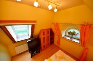 Habitación amarilla con TV y ventana en Sonnenkamp OG en Gager