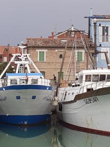 due barche parcheggiate l'una accanto all'altra in acqua di Una finestra sul mare - Appartamento a Fano a Fano
