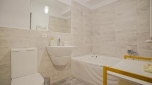 a bathroom with a tub and a toilet and a sink at Coroni Apart 1 Cu Vedere Panoramica Brasov in Braşov +13 photos