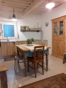 cocina con mesa de madera, sillas y fregadero en Una finestra sul mare - Appartamento a Fano, en Fano