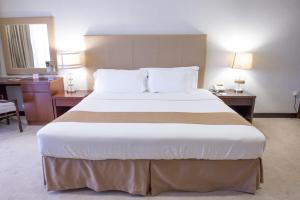 Ένα ή περισσότερα κρεβάτια σε δωμάτιο στο Al Qurum Resort