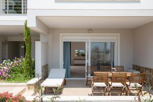 a patio with a table and chairs and flowers at Kymata Apartment Ierapetra in Ierapetra