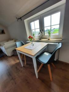 - une salle à manger avec une table et deux chaises dans l'établissement Apartment Weitblick, à Butjadingen