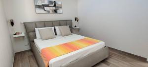a bedroom with a bed with a colorful blanket on it at Le casette in Monopoli