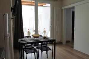 a dining room table with chairs and a large window at Le casette in Monopoli