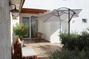a patio with an umbrella and chairs and a table at Le casette in Monopoli