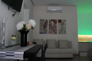 a living room with a table with a vase of flowers at Le casette in Monopoli