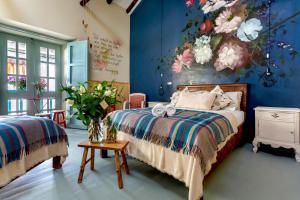 ein Schlafzimmer mit einem Bett und einem Blumengemälde in der Unterkunft Niños Hotel Fierro in Cusco