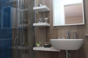 a bathroom with a sink and a shower with a mirror at Le casette in Monopoli