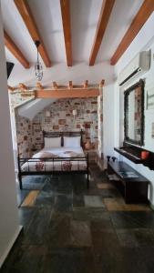um quarto com uma cama e uma parede de tijolos em Aegean Wave - Faros em Loutraki