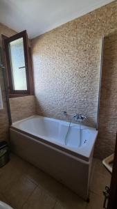 a bath tub in a bathroom with a mirror at Aegean Wave - Faros in Loutraki