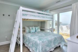 a white bunk bed in a bedroom with a balcony at Drift Away in Oak Island +50 photos