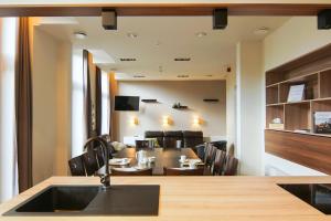 una cucina e una sala da pranzo con tavolo e sedie di Het Dorpshuys - vakantiewoning tot 12 personen a Maaseik