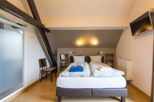 sypialnia z dużym łóżkiem w pokoju w obiekcie Het Dorpshuys - vakantiewoning tot 12 personen w mieście Maaseik