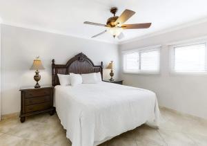 a white bedroom with a bed and a ceiling fan at Beach House by TS in Destin