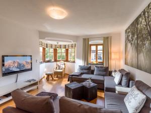 a living room with a couch and a tv at Villa Grete, St. Johann in Tirol in Sankt Johann in Tirol