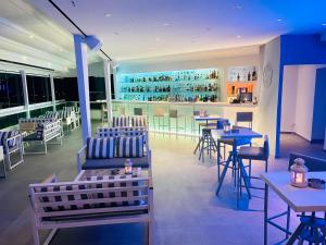 un restaurante con mesas y sillas y un bar en Loucas on the Cliff, en Fira