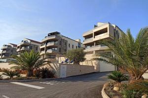 a parking lot in front of a building with palm trees at Apartment Emarin in Banjole