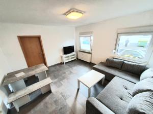 ein Wohnzimmer mit einem Sofa und einem Tisch in der Unterkunft Lieblingsmensch Oberhausen mit Terrasse in Oberhausen