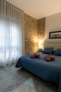 Un dormitorio con una cama azul y una pared de piedra en Casa Estrella y Casa Carmen, en Denia
