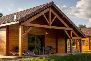 a log cabin with a table and chairs at Les Jardins du Hérisson Chalet 2 in Bonlieu