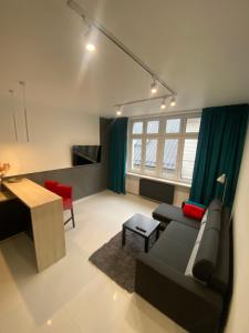 ein Wohnzimmer mit einem Sofa und einem Tisch in der Unterkunft Apartamenty Planeta in Bielsko-Biała
