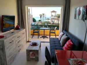 un soggiorno con divano, TV e balcone di Apartamento Playa de las vistas Torres del Sol C3 308 ad Arona