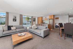 a living room with two couches and a table at Waimahana 5 - Taupō Holiday Apartment in Taupo