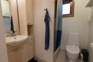 a bathroom with a toilet and a sink at Pouls Airport Guesthouse - PHD Car Rent in Sørvágur