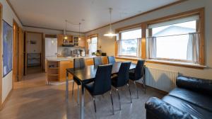 a kitchen and living room with a table and chairs at Pouls Airport Guesthouse - PHD Car Rent in Sørvágur