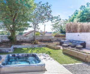 a backyard with a hot tub in the grass at Lovely 1-Bed Cottage in Kelty with Hot Tub in Kelty