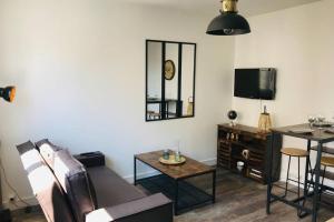 a living room with a couch and a table at Appartement 2/3 pers, centre ville avec parking. in Saint-Brevin-les-Pins