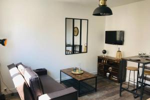 ein Wohnzimmer mit Sofa und Tisch in der Unterkunft Appartement 2/3 pers, centre ville avec parking. in Saint-Brevin-les-Pins