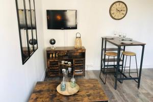 ein Wohnzimmer mit einem Tisch, einem Tisch und einem Tisch in der Unterkunft Appartement 2/3 pers, centre ville avec parking. in Saint-Brevin-les-Pins + 2 Fotos