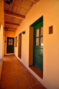 a green door on the side of a building at Hosteria la granja in Huacalera