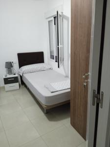 een klein bed in een kamer met een raam bij pension mexico in Alicante