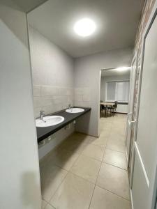 a bathroom with two sinks and a table at Апартаменты Проспект Победы 101 in Chernihiv